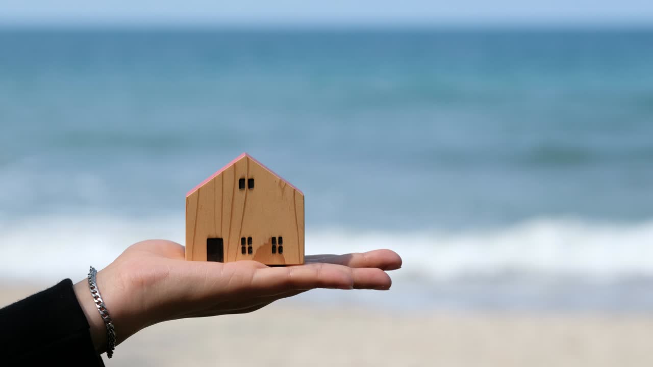 바다 배경, 미니어처 집과 함께 손에 작은 집 모델