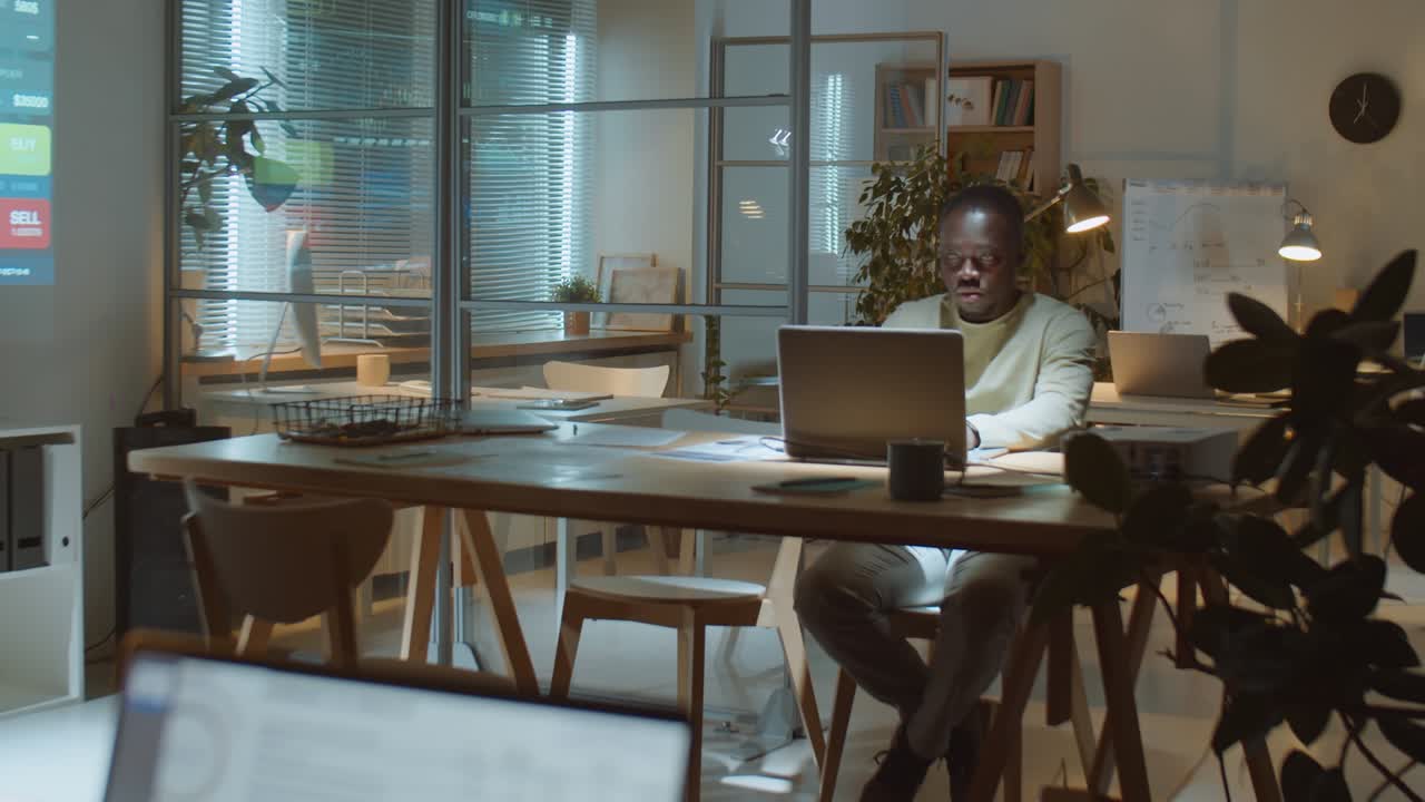 Black Businessman Working on Laptop Late in Office