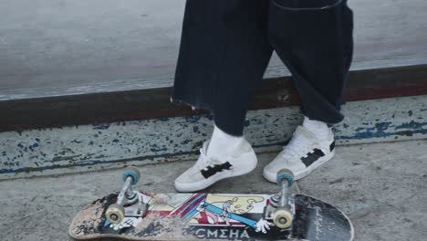 Stylish-skater-girl-skating-and-trying-to-perform-a-skateboard-trick-and-failing,-low-angle-close-up