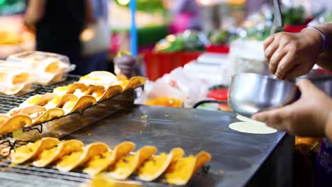 vendor prepares traditional thai crispy pancakes