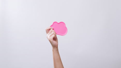 la mano de la mujer muestra un símbolo de color rosa de icono de nube en fondo de estudio blanco con espacio de copia
