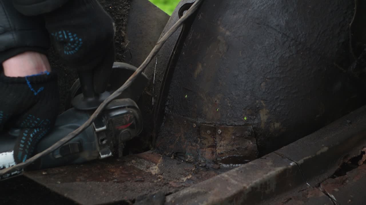 un uomo in guanti segha il metallo con un disco da taglio. macinatore ad angolo. lavorare con il metallo. fiammeggianti spruzzi luminosi dal disco. riparazione auto. meccanico di lavori di assemblaggio meccanico