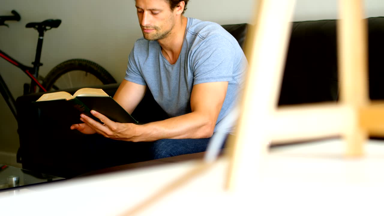 hombre leyendo un libro en la sala de estar 4k