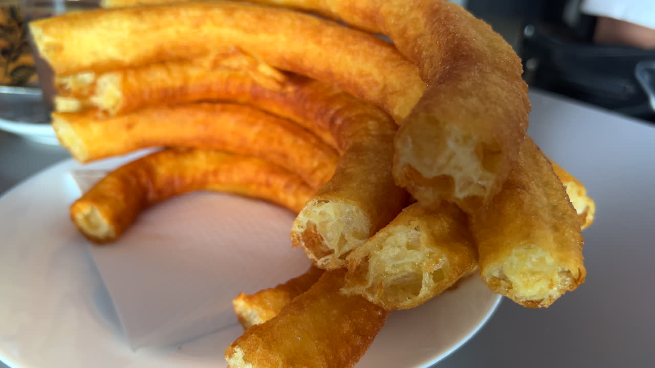 Traditional Spanish churros porras in a restaurant in Marbella Malaga Spain, delicious deep fried dough dessert, 4K shot
