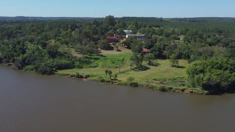 Filmische-Luftaufnahmen-Der-Yerba-Mate-Verarbeitungsanlagen-Mit-Blick-Vom-Fluss-Aus,-Drohne