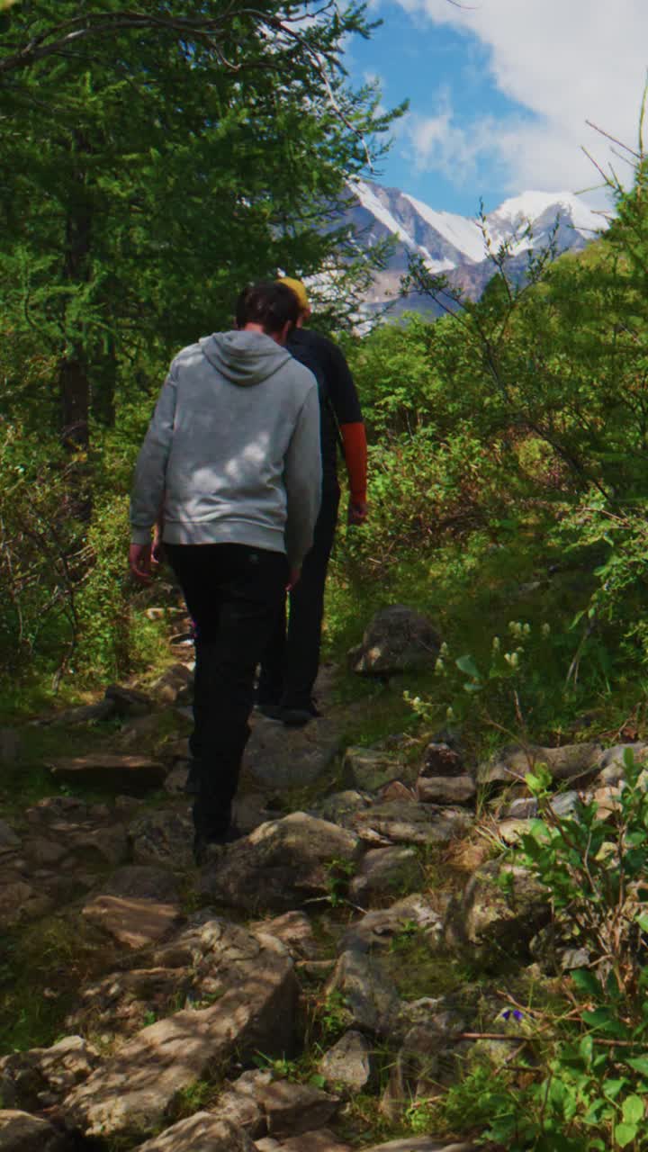 Gruppo di persone in escursione in salita su un sentiero di montagna roccioso