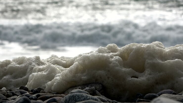 Schiuma di alghe durante una tempesta sulla spiaggia, spiaggia sabbiosa con onde, Mare del Nord, Jütland, Sondervig, Danimarca, 4K