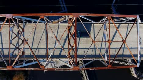 vista de pájaro de un viejo puente, un coche negro pasa a través