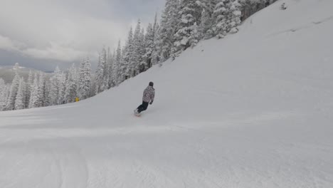 snowboarder spin and ollie down the slopes of aspen, colorado