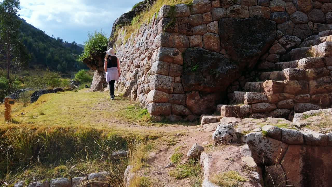 Close up, pan left view of stone stairways at Inkilltambo ruins, Cusco, Peru. Caucasian brunette woman tourists walks alongside terraced walls ====