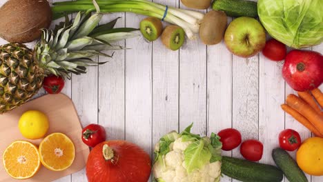 fresh fruits and vegetables make frame for text or logo on wooden theme. stop motion