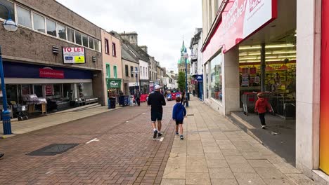 people walking along a busy shopping street