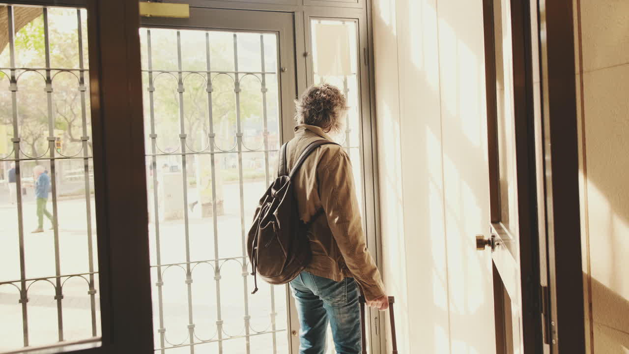 Hombre entrando en un edificio con una mochila