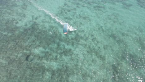 Aerial-tracking-shot-of-kitesurfer-surfing-on-board-In-Pacific-Ocean-during-sunny-day,Australia