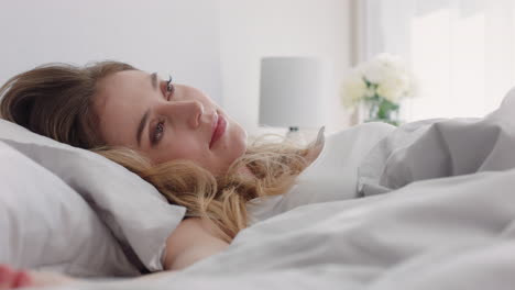 beautiful-caucasian-woman-waking-up-in-bed-after-restful-sleep-smiling-happy-ready-for-new-day