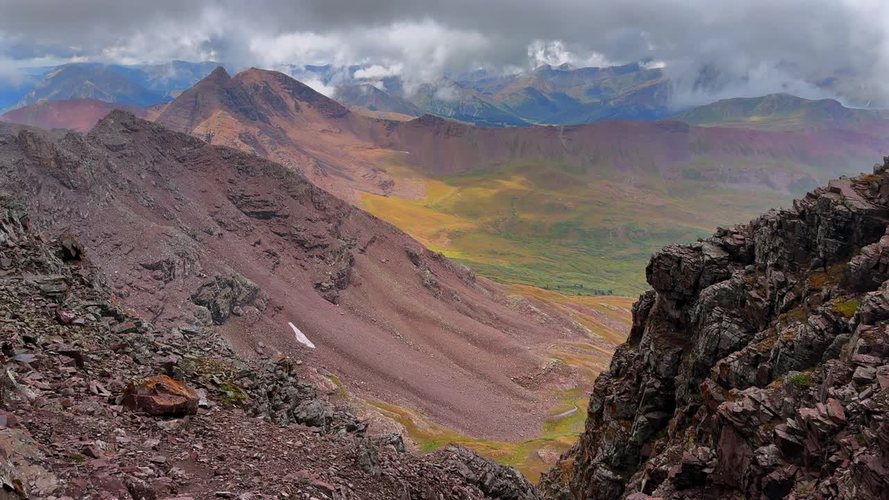 Summer Maroon Bells Wilderness Conundrum Castle Peak backside valley Maroon Peak hiking fourteener Colorado sunny fog cloud movement Aspen Snowmass rugged terrain Elk Range Rocky Mountains pan left