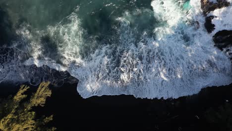 Las-Olas-Turquesas-Chocan-Contra-La-Playa-De-Arena-Negra-Volcánica-En-Hawaii