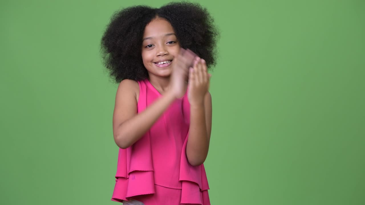 Young happy African girl with Afro hair clapping hands