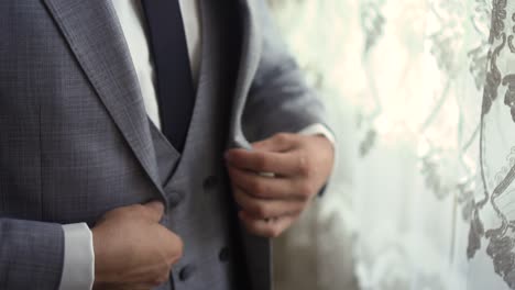 man buttons on gray jacket