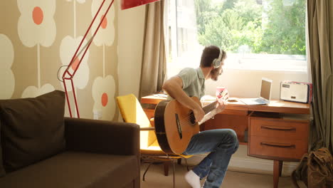 man playing guitar at home