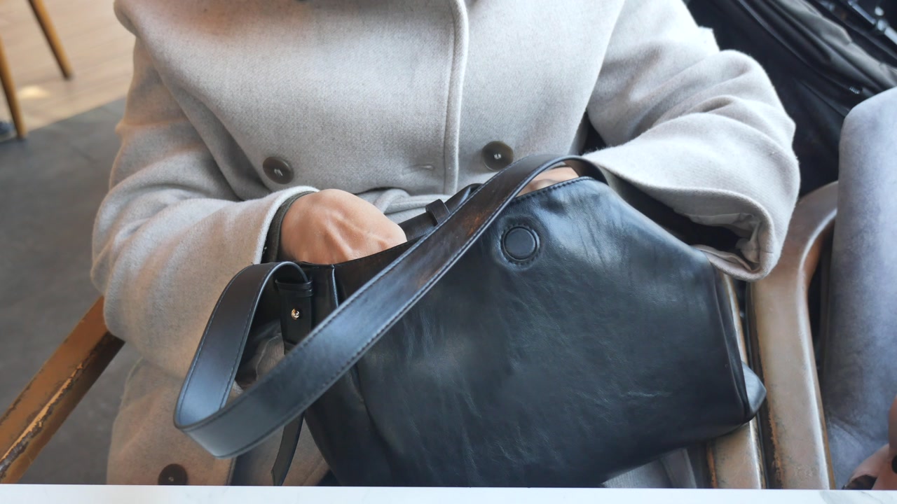 Woman's Hands Searching Inside a Black Handbag