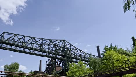 big metal crane of duisburg nord landscape park in germany, historical abandoned area for steel production between nature and sunshine