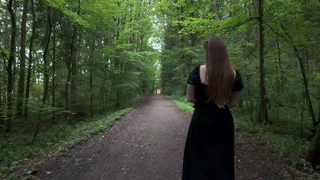 woman walking down a forest path