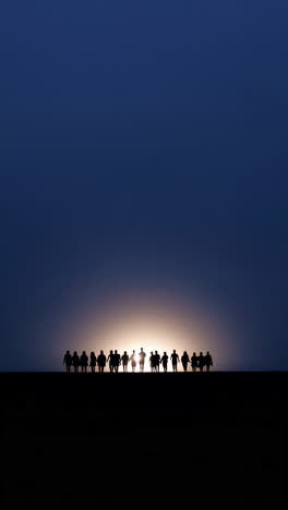 silhouettes of a group of people against a sunset