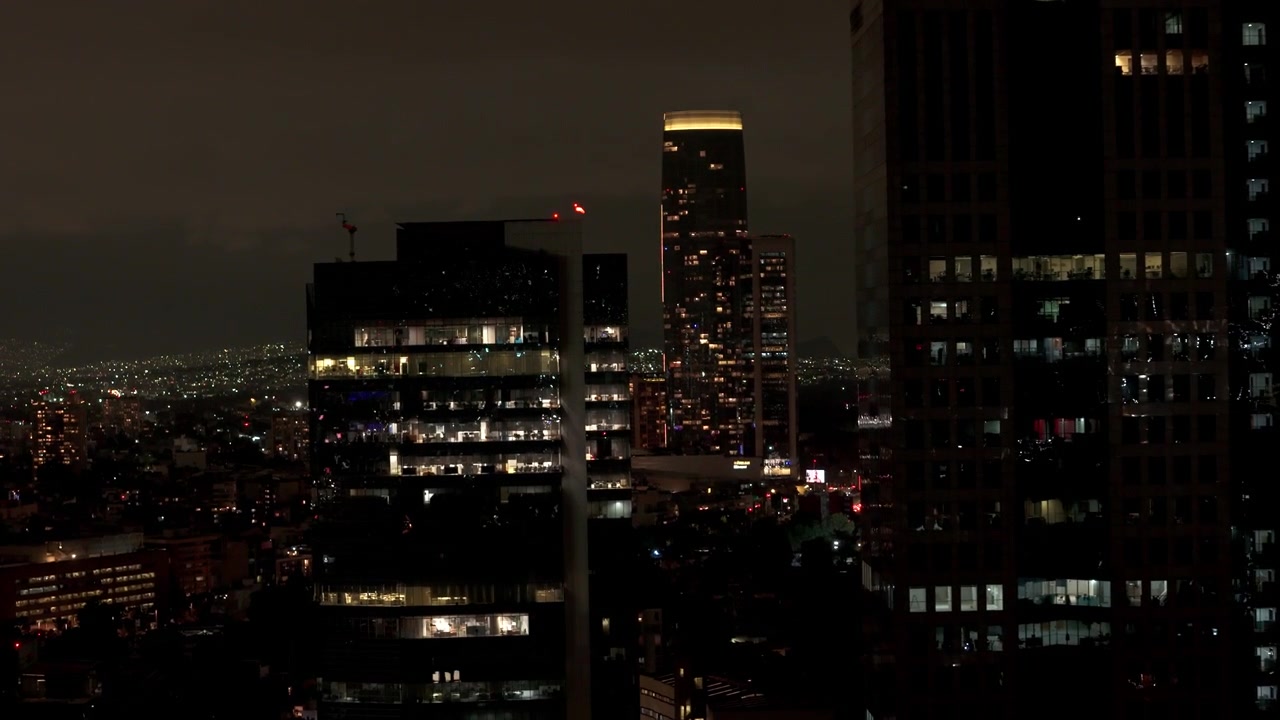 Aerial night view of Mexico City skyline with illuminated windows