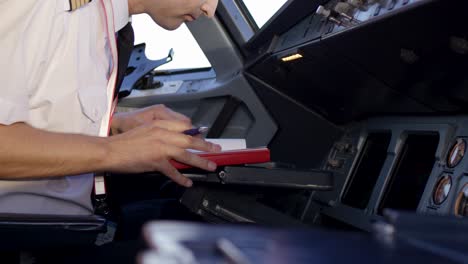 pilot reviewing flight documents in cockpit