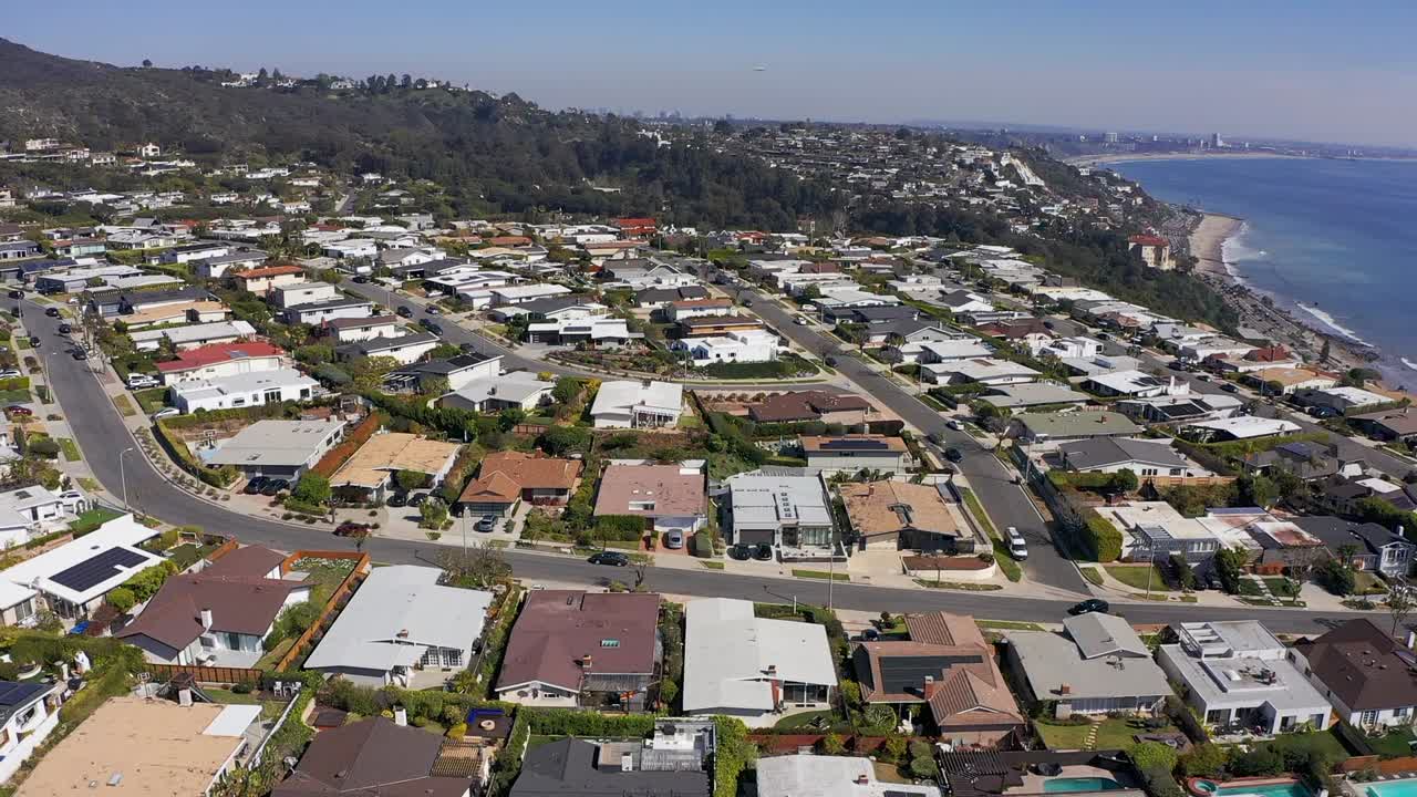 캘리포니아 해안을 따라 있는 말리부 절벽 주택 커뮤니티의 넓은 역방향 공중 풀백 샷