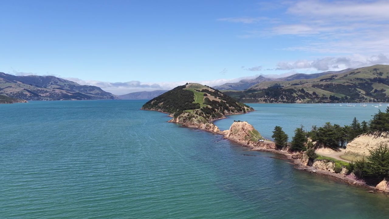 Una vista aerea della penisola di Onawe nella baia di Akaroa, Nuova Zelanda. L'acqua calma e blu in una giornata di sole