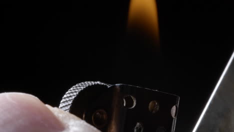 slow-motion-close-up-of-a-thumb-striking-a-metal-lighter-igniting-the-blue-flame