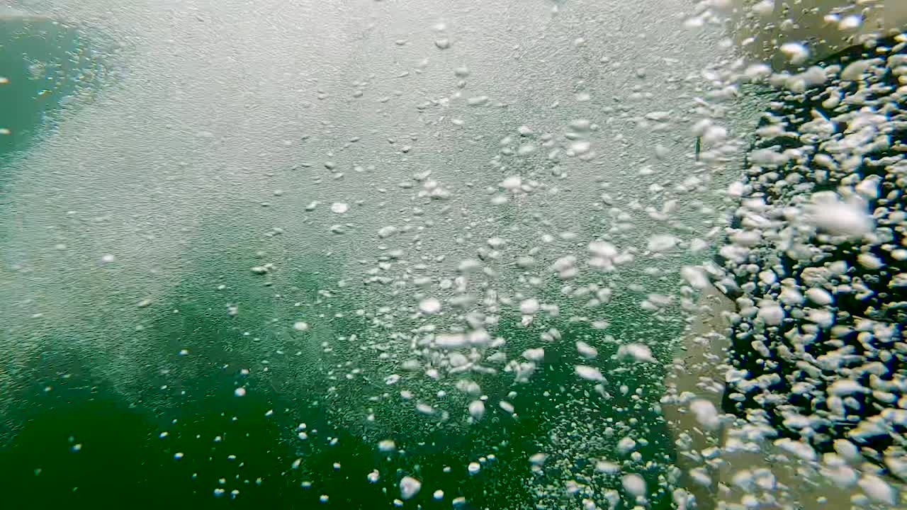 젊은 백인 남성과 함께 키 큰 바위 절벽에서 푸른 호수로 뛰어내리고, pov 와이드 액션 추적