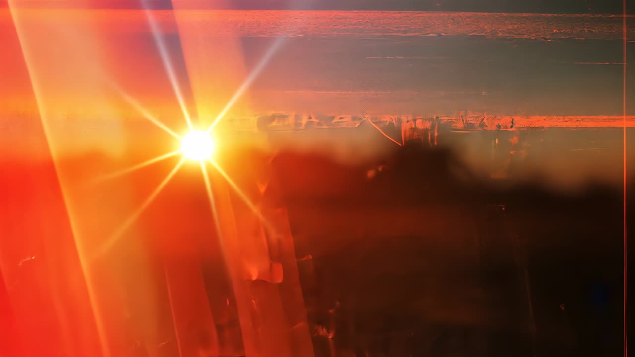 Emerging sun casting orange lens flare in room through scratched pane, descending toward silhouette