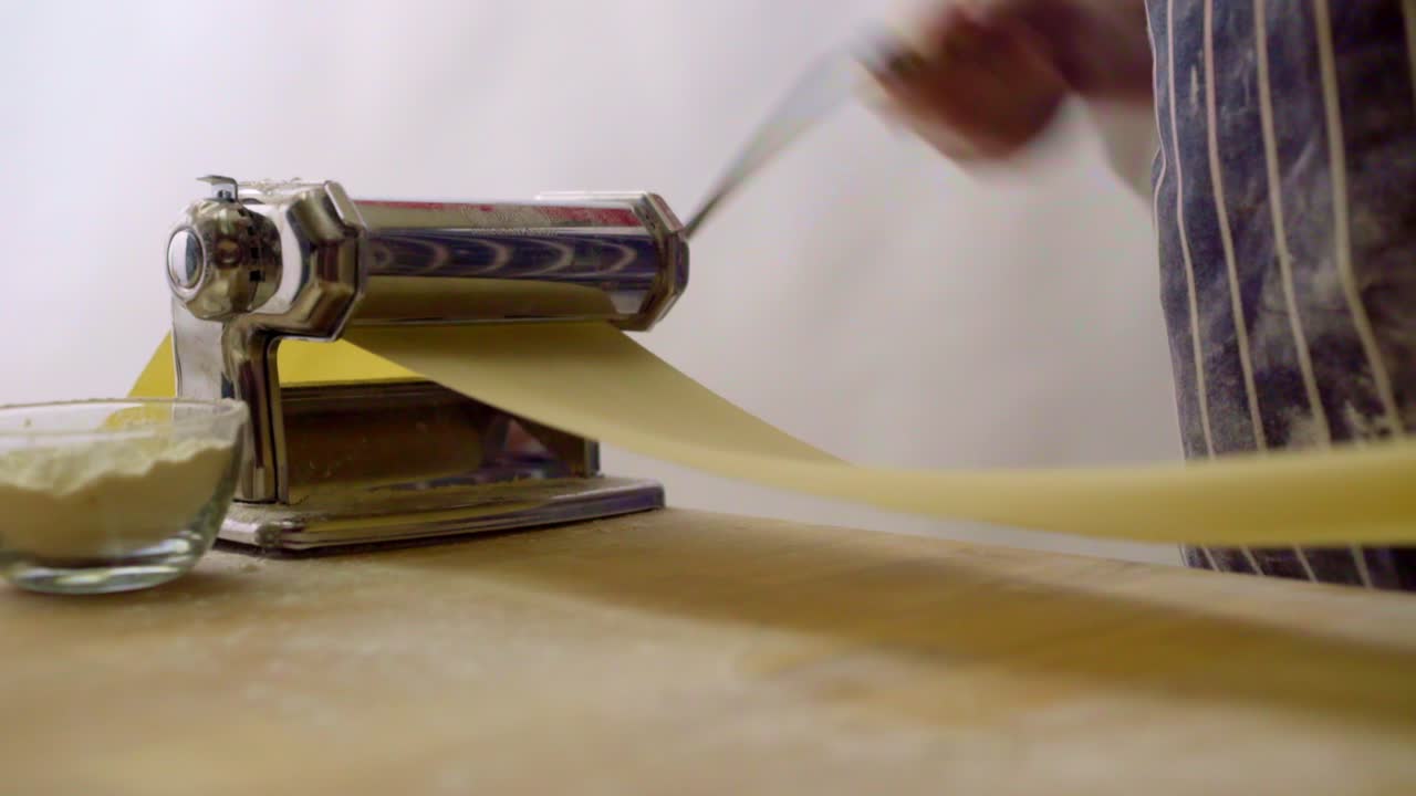 Pasta che passa attraverso una macchina per la pasta.
