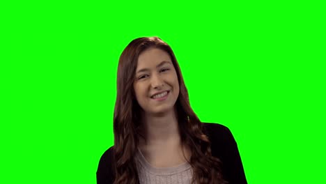 Smiling-beautiful-woman-standing-against-green-screen