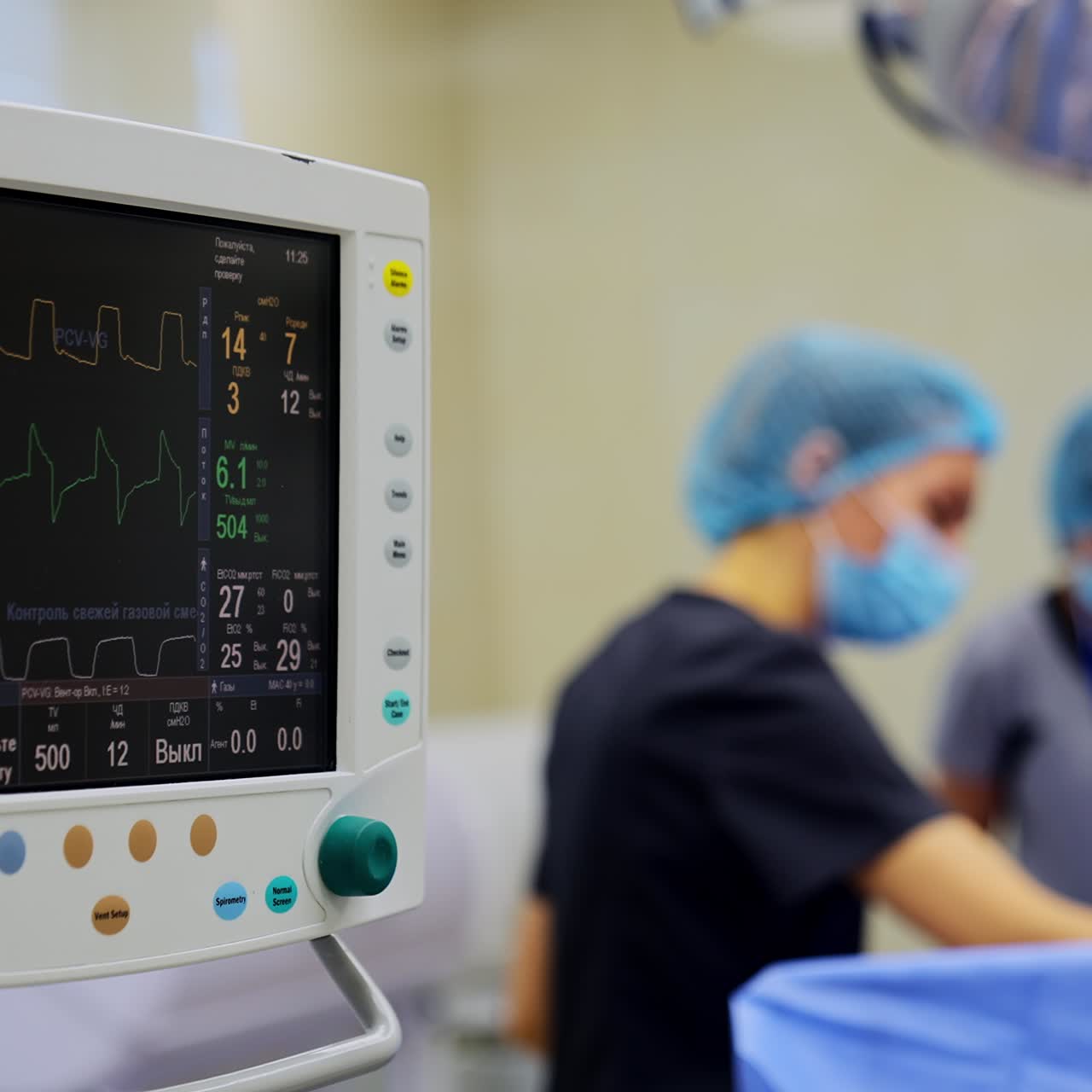 Screen with diverse parameters shown during operation. Equipment for measuring and controlling life signs of a patient. Close up. Doctors working at backdrop in blur