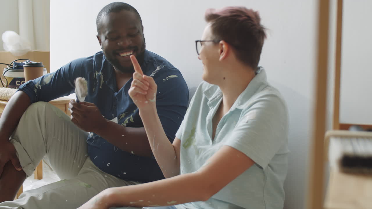 una pareja pintando su nueva casa.