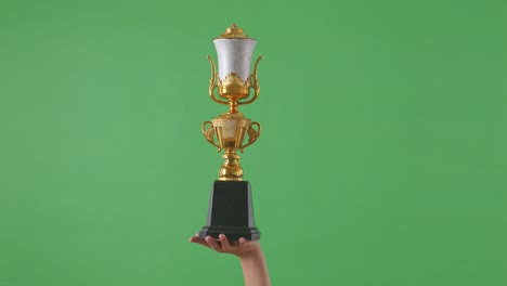 woman holding a champion golden trophy. green screen background