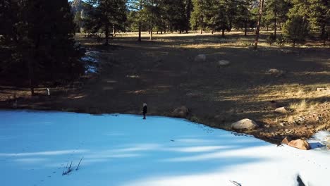 Mädchen,-Das-Auf-Dem-Zugefrorenen-Weißen-See-In-Den-Colorado-Mountains-Spaziert