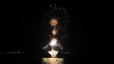 espectáculo de fuegos artificiales sobre una bahía justo después del atardecer