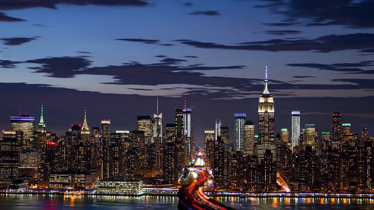 Aerial view of a city skyline at dusk with light trails, capturing a dynamic, cinematic video style