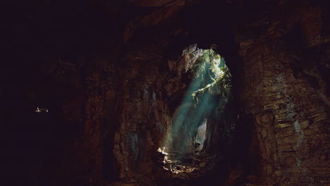 mysterious cave illuminated by natural light beams in a dark environment