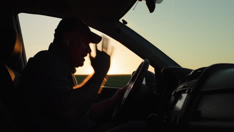 the angry driver is talking through the earpiece, gesticulating vigorously. road accident concept