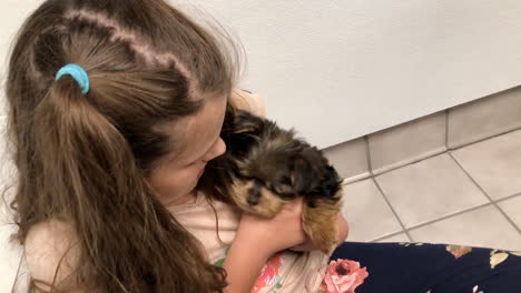 niña sentada en el suelo jugando con cachorro