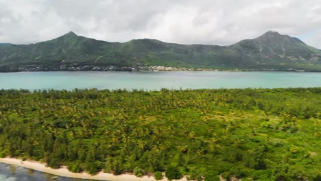 panning shot of the ile aux benitiers in mauritius with mountains in the background