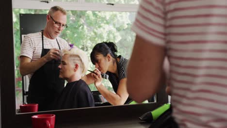 side view woman having her hair styled by hairdressers
