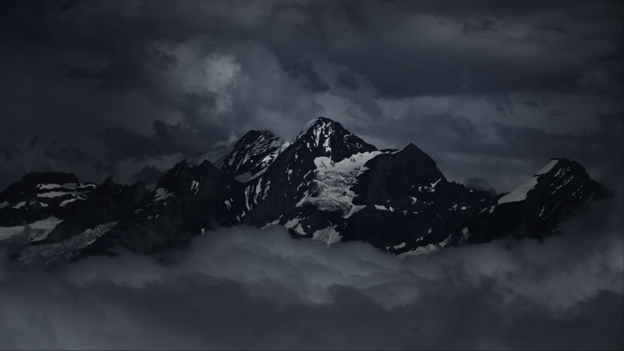 Picos de Montanha Escuros Atravessados por Nuvens de Tempestade