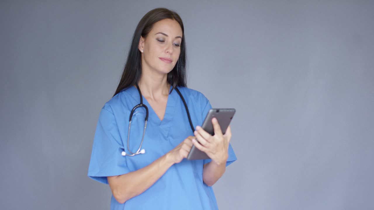 Joven doctora con uniforme médico usando una tablet